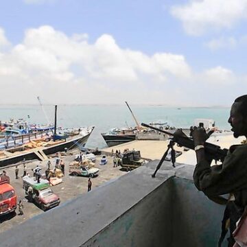 A soldier from Somalia's Ras-Kamboni paramilitary group stands guard as he monitors activities at the sea port in lower juba regions in Kismayu Somali government says guns won’t decide disputed port’s fate