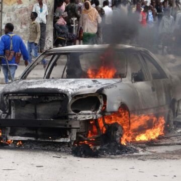 A soldier walks away from burning car after it exploded in Sanca in Yaqshid district north of capital Mogadishu